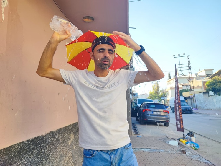 Aşırı Sıcaklar Sonrası Çareyi Başına Şemsiye Takmakta Buldu!